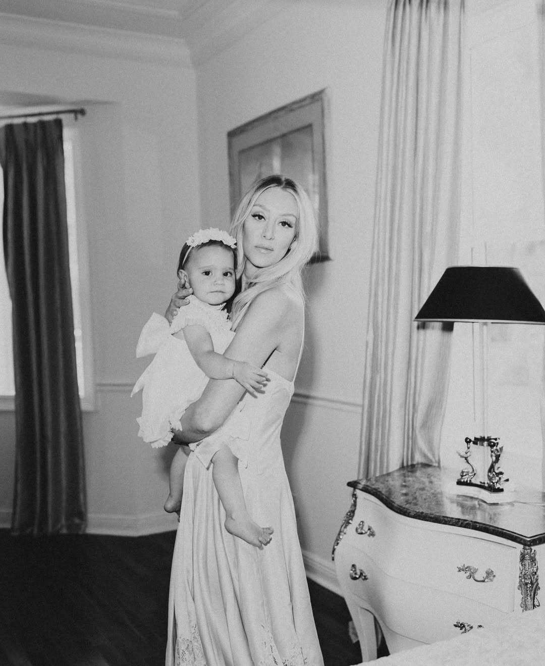 Black and white portrait of mother and child by a marble dresser at Maison Sarti
