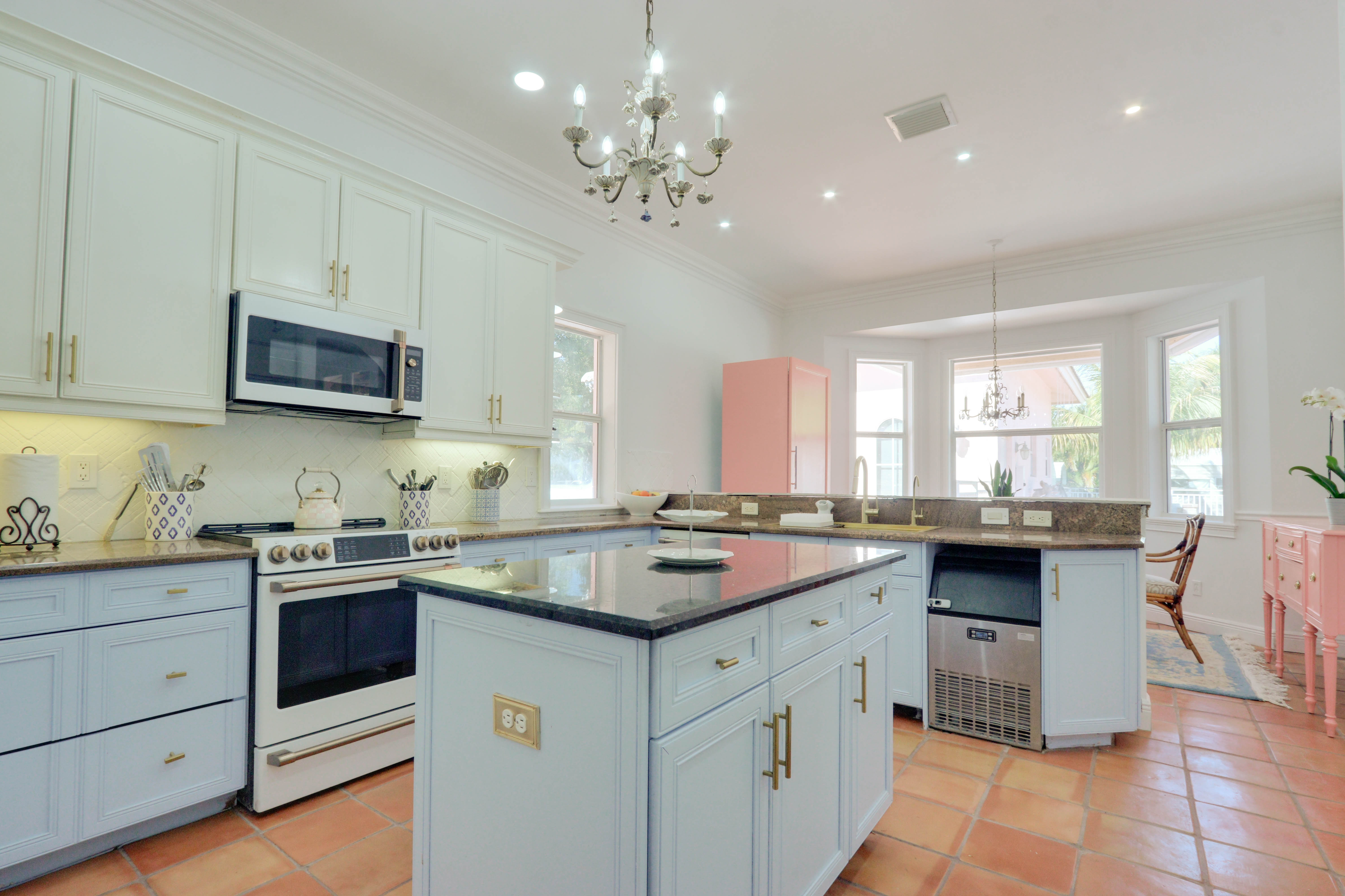 Maison Sarti culinary kitchen with pale blue cabinets and pink accents