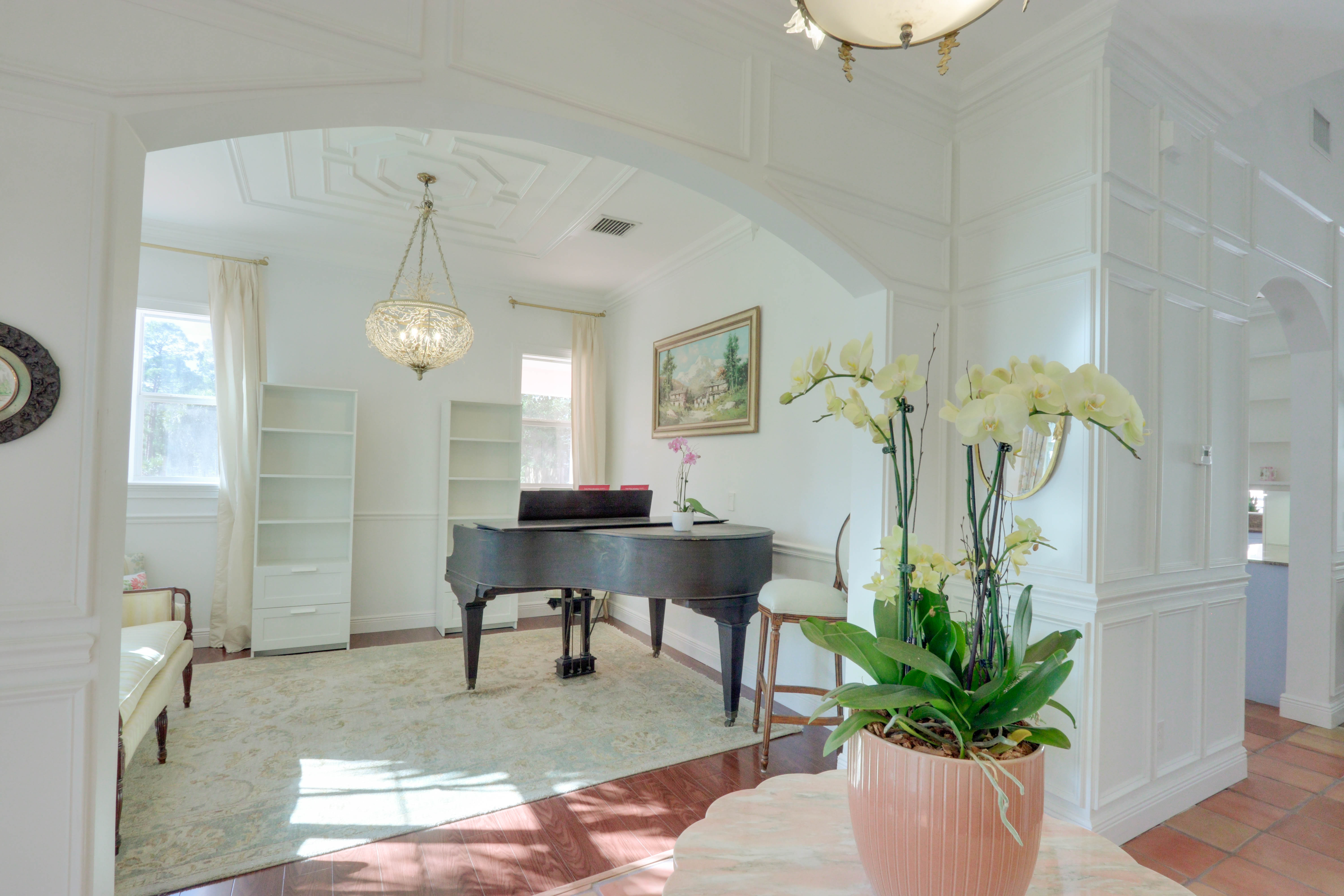 Maison Sarti Piano Room and Grand Salon with grand piano seen through an arched doorway
